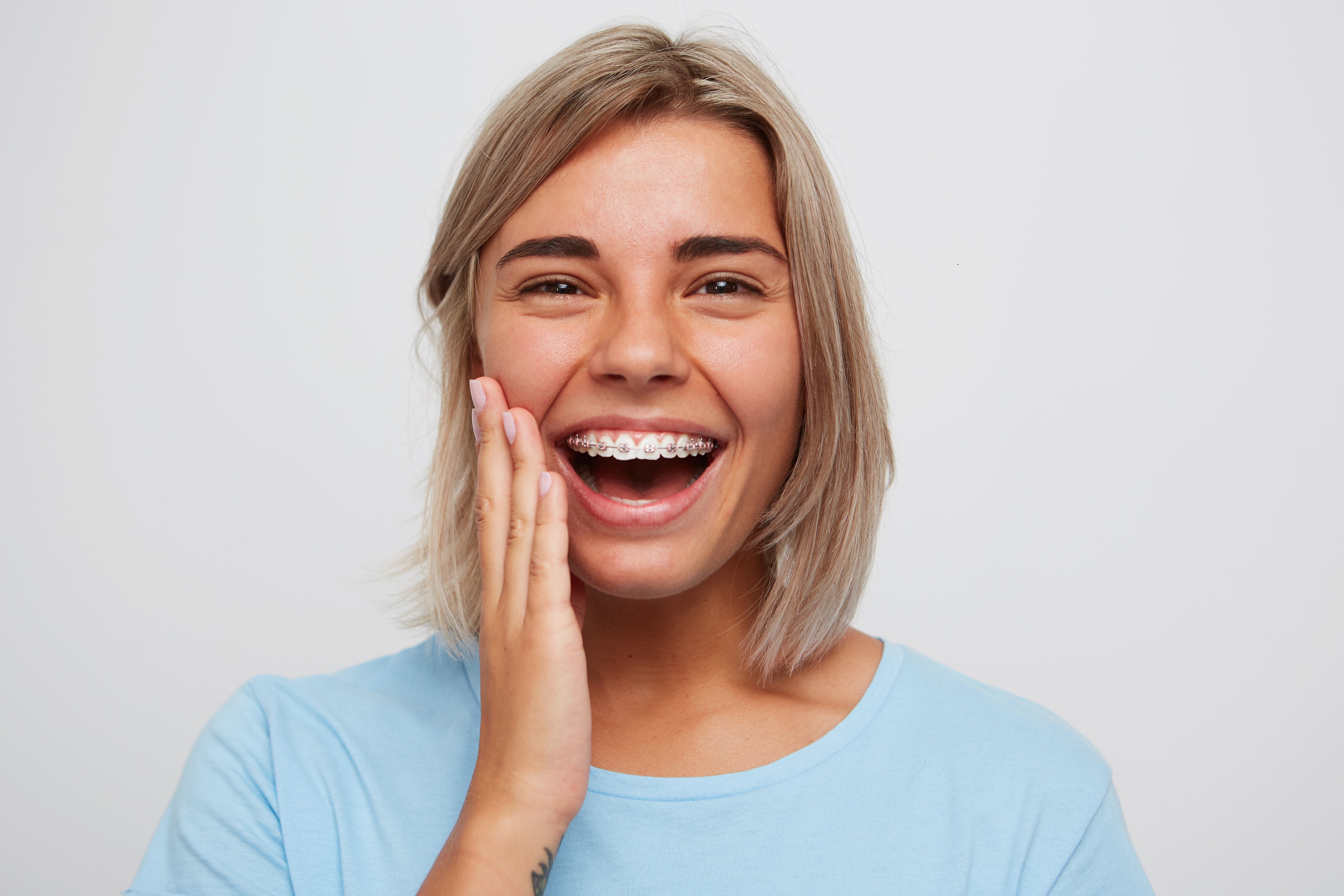cheerful blonde woman wearing traditional braces